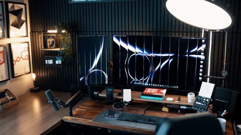 Dark wood gaming desk setup with monitor and lamp